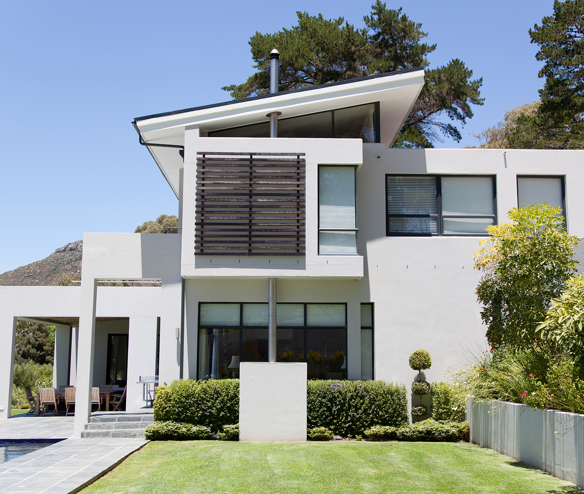 Modern house with large windows and garden.